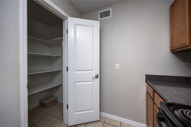 interior space with light tile patterned floors and a textured ceiling