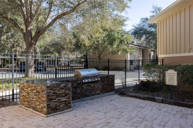 view of patio featuring an outdoor kitchen and a grill