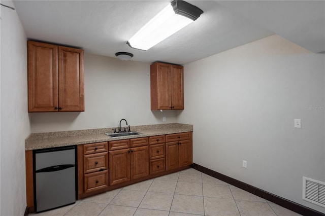 kitchen with sink, light tile patterned floors, and refrigerator