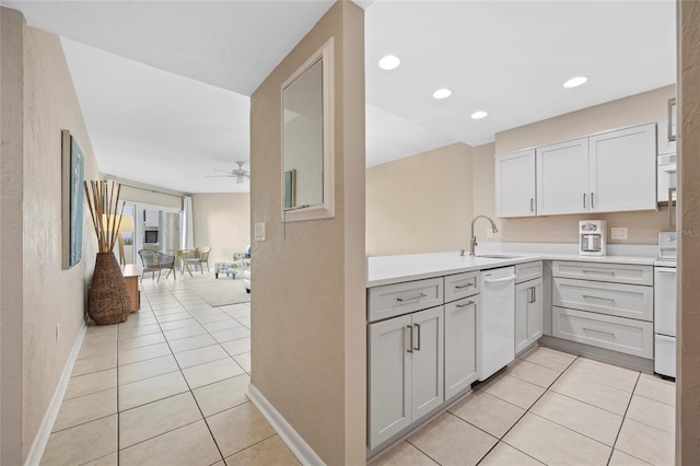 kitchen with light tile patterned flooring, sink, white appliances, ceiling fan, and white cabinets