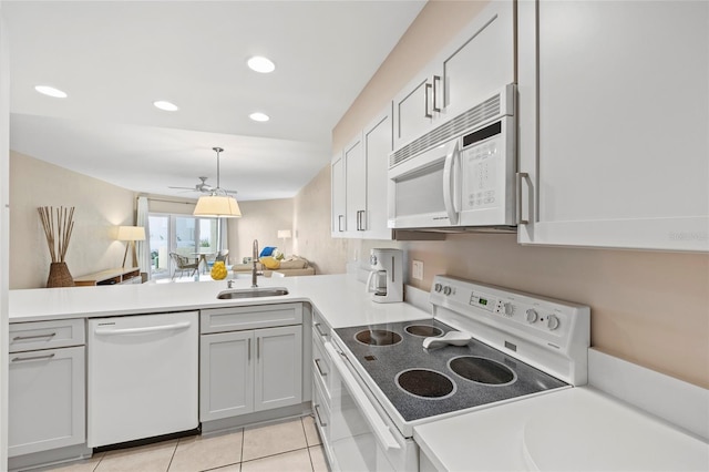 kitchen with sink, white cabinetry, light tile patterned floors, kitchen peninsula, and white appliances