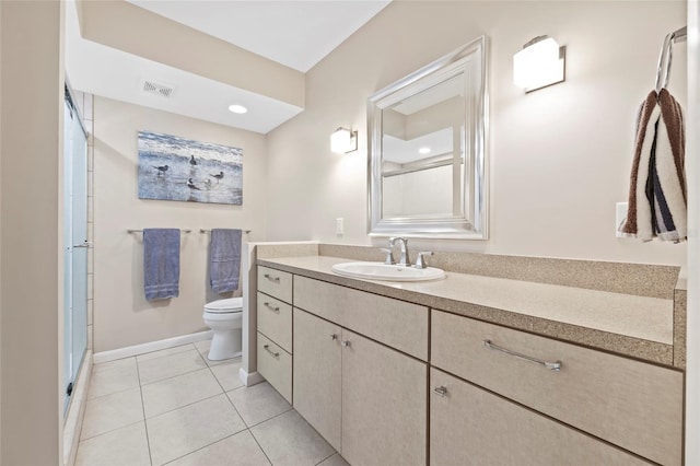 bathroom with tile patterned flooring, vanity, a shower with door, and toilet