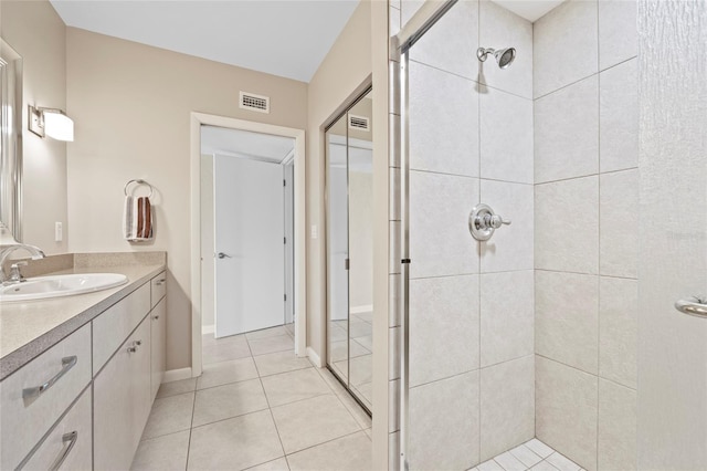 bathroom featuring vanity, tile patterned flooring, and tiled shower