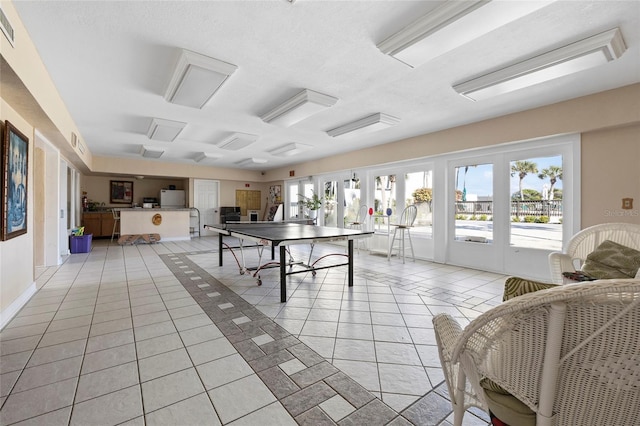 playroom with light tile patterned flooring and a textured ceiling