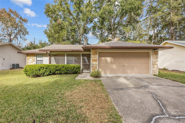 single story home featuring a garage, a front yard, and cooling unit