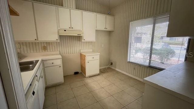 kitchen with light tile patterned flooring, a wealth of natural light, sink, and white cabinets