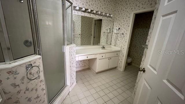 bathroom featuring vanity, walk in shower, tile patterned floors, and toilet