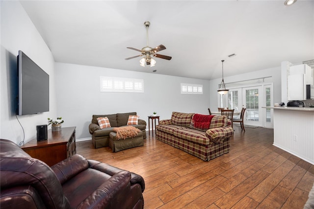 living room with dark wood-type flooring, ceiling fan, and french doors