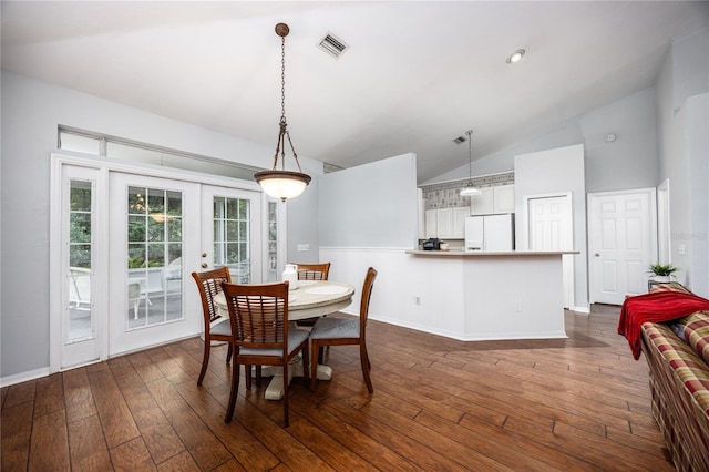 dining room with french doors, dark wood-type flooring, and vaulted ceiling