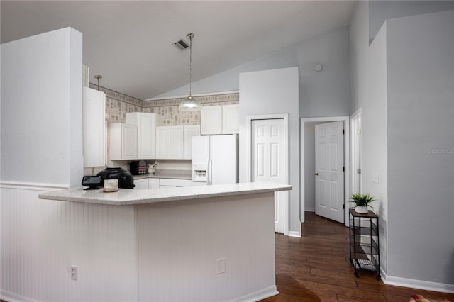 kitchen featuring white cabinetry, lofted ceiling, white fridge with ice dispenser, and kitchen peninsula