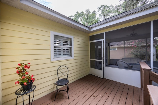 wooden terrace featuring ceiling fan and a sunroom