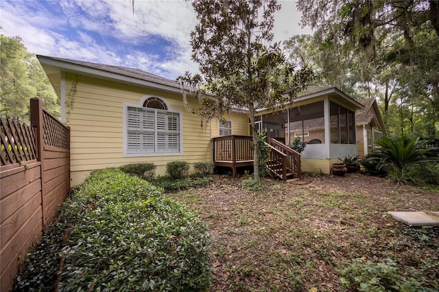 back of house featuring a sunroom and a deck