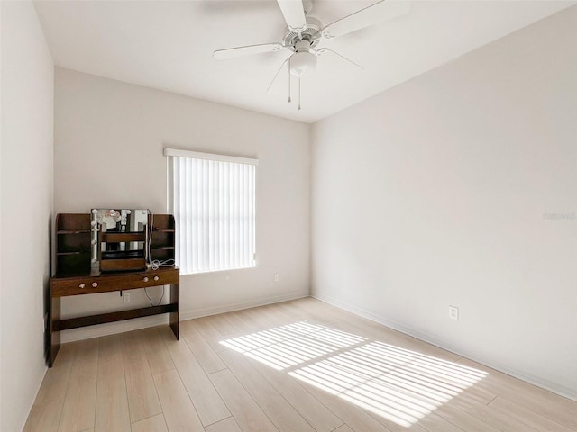 empty room with ceiling fan and light hardwood / wood-style floors