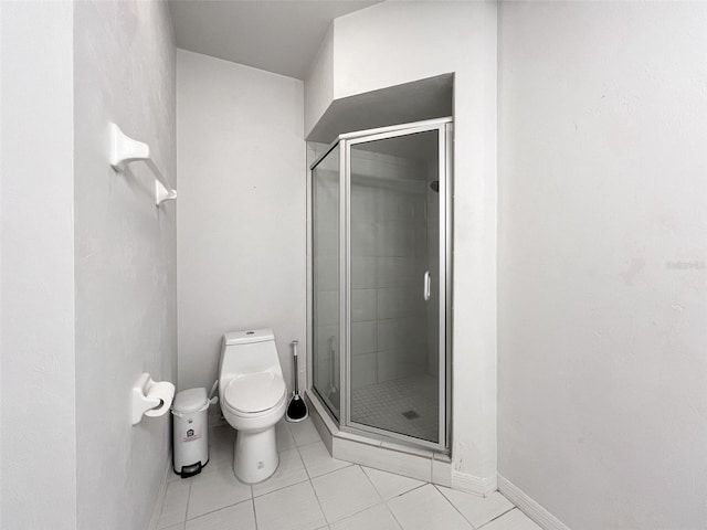 bathroom with tile patterned floors, toilet, and a shower with shower door