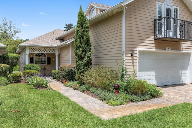 view of property exterior featuring a garage and a lawn