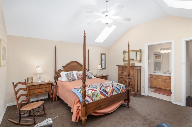 bedroom with lofted ceiling with skylight, sink, ceiling fan, light carpet, and ensuite bath