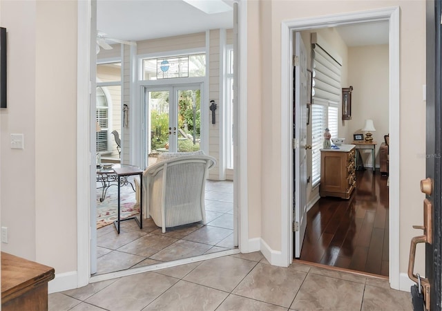 hallway with plenty of natural light, french doors, and light tile patterned flooring