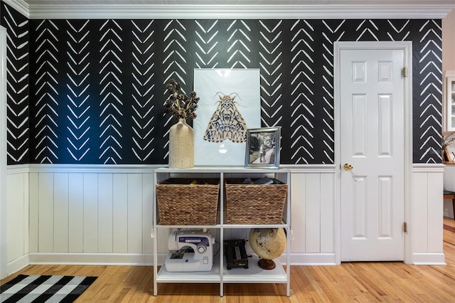 room details with wallpapered walls, ornamental molding, and wood finished floors