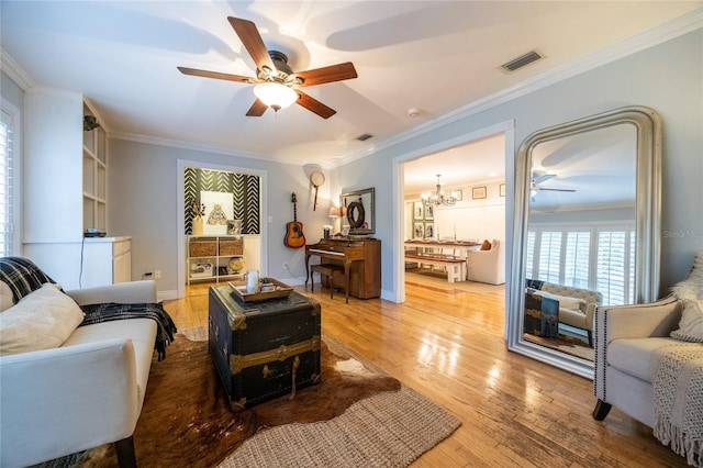 living area with light wood-type flooring, visible vents, and crown molding