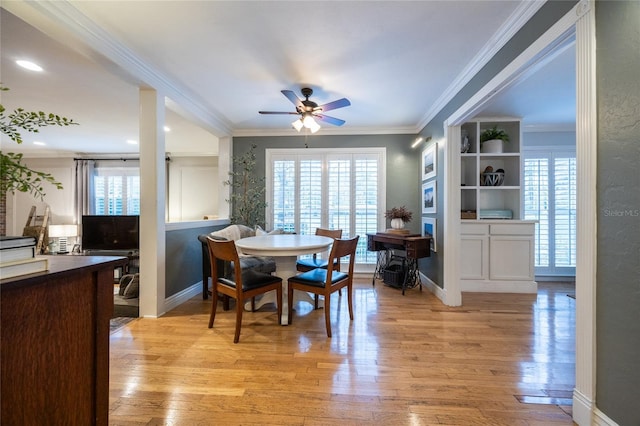 dining room featuring light wood finished floors and crown molding