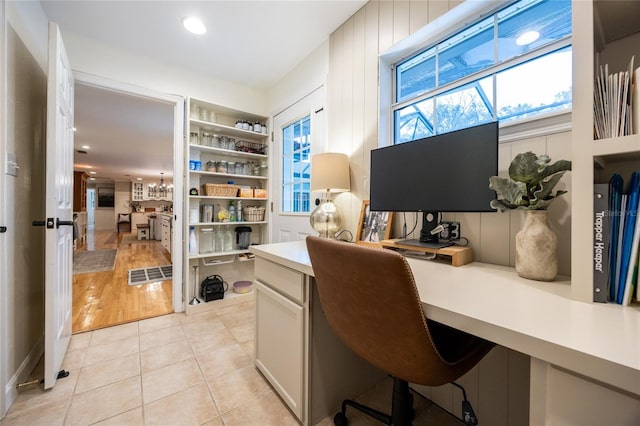 office area with built in shelves, visible vents, built in study area, and light tile patterned flooring