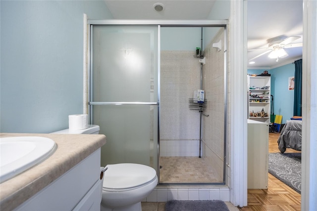 full bath with a stall shower, a ceiling fan, toilet, crown molding, and vanity