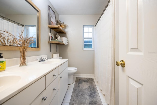 full bathroom with double vanity, baseboards, toilet, tile patterned floors, and a sink