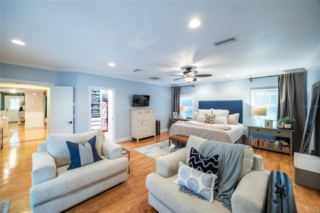 bedroom with light wood-type flooring, multiple windows, visible vents, and crown molding