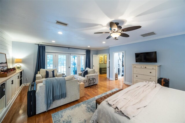 bedroom with visible vents, crown molding, and wood finished floors