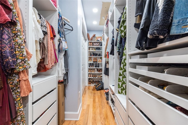 walk in closet with light wood-style floors