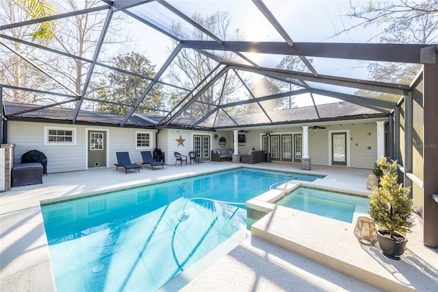 view of swimming pool with a patio, a lanai, outdoor lounge area, a pool with connected hot tub, and a ceiling fan