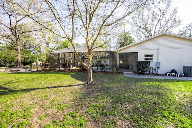 view of yard featuring a lanai and central air condition unit