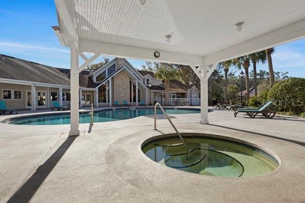 view of pool featuring a patio and an in ground hot tub