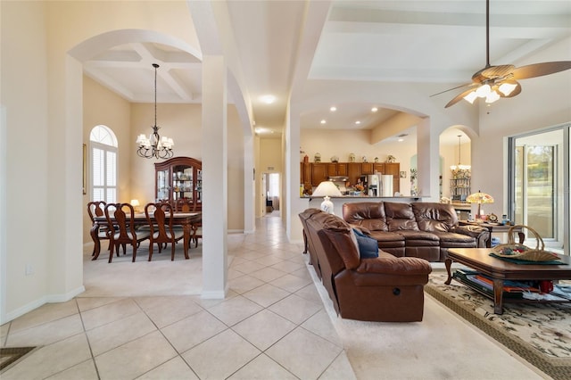 living room with coffered ceiling, light tile patterned floors, ceiling fan with notable chandelier, and beamed ceiling