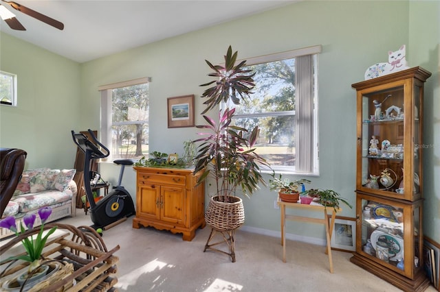 interior space featuring light colored carpet and ceiling fan