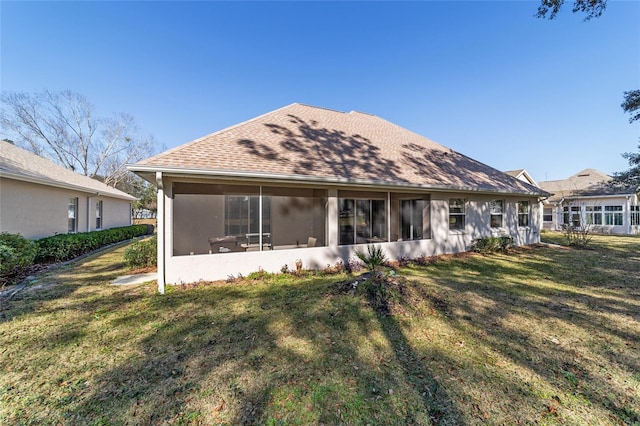 rear view of house featuring a yard and a sunroom