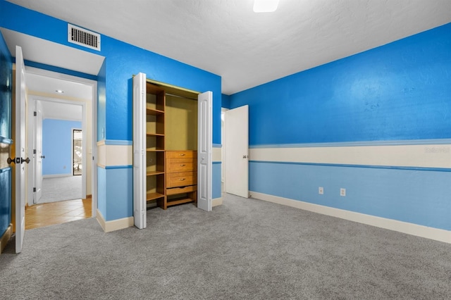 unfurnished bedroom with a closet and carpet flooring