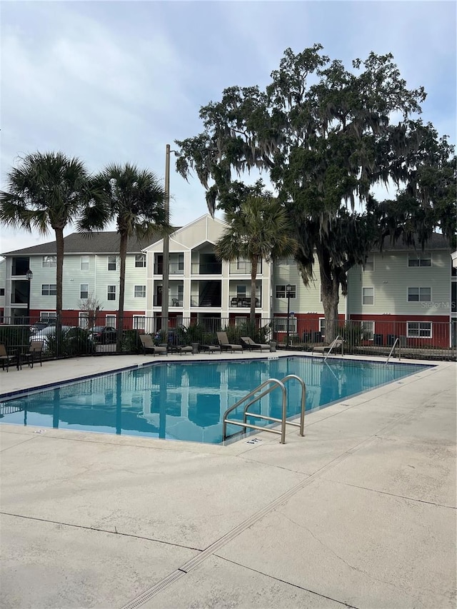 community pool featuring a patio and fence