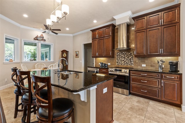 kitchen featuring electric stove, wall chimney range hood, a breakfast bar area, a center island with sink, and dark stone counters