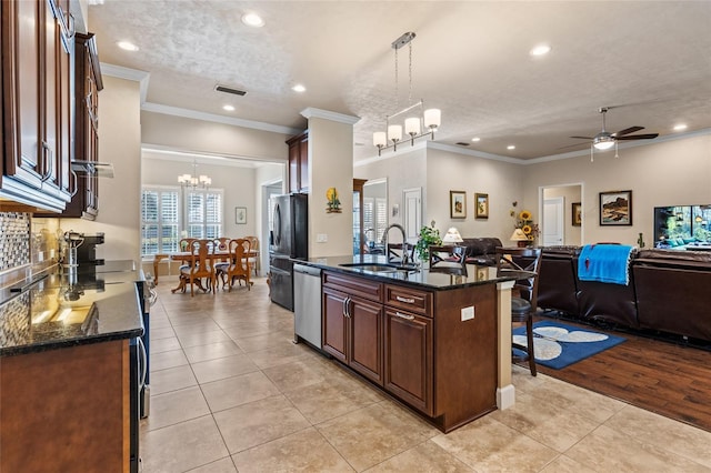 kitchen featuring appliances with stainless steel finishes, decorative light fixtures, sink, and light tile patterned floors