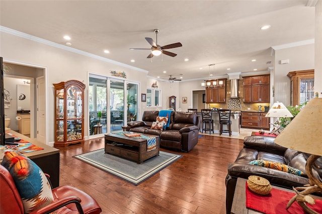 living room with dark wood-type flooring, ornamental molding, and ceiling fan