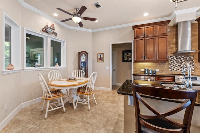 kitchen with tasteful backsplash, ornamental molding, dark stone countertops, and wall chimney exhaust hood