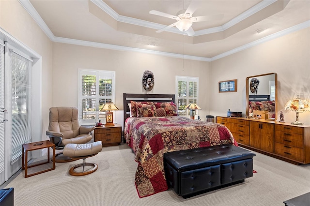 carpeted bedroom with multiple windows, a tray ceiling, and ornamental molding