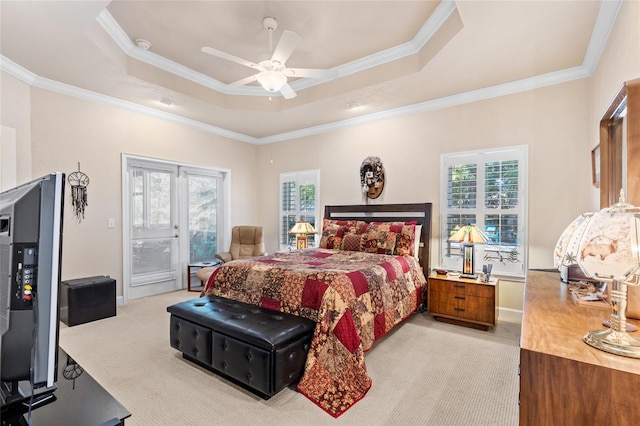 carpeted bedroom featuring ornamental molding, a raised ceiling, and access to outside