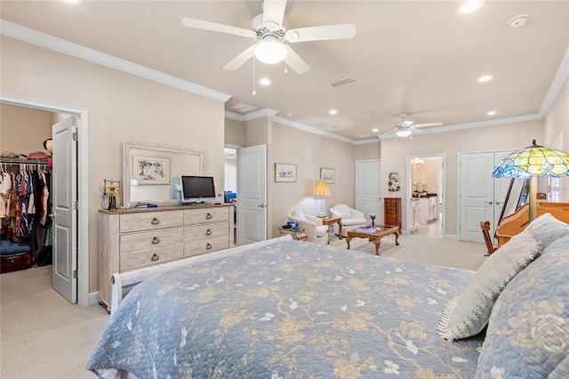 carpeted bedroom featuring crown molding, a walk in closet, a closet, and ceiling fan