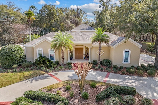 mediterranean / spanish-style house with roof with shingles and stucco siding