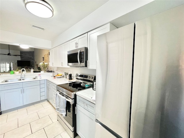 kitchen with light tile patterned flooring, white cabinetry, sink, ceiling fan, and stainless steel appliances