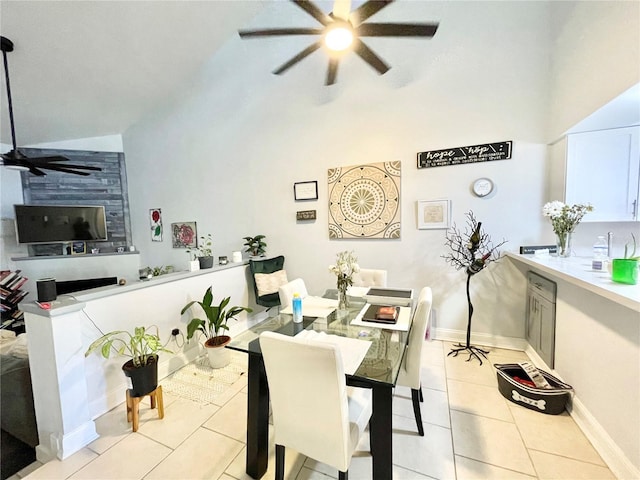 tiled dining room featuring a high ceiling and ceiling fan