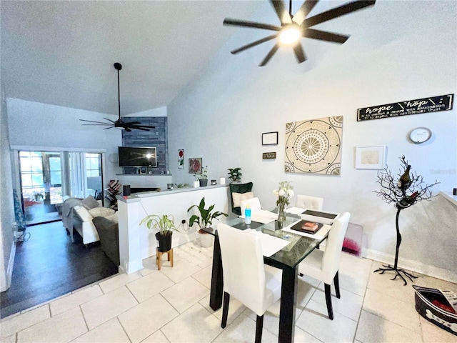 dining area with light tile patterned floors, high vaulted ceiling, and ceiling fan