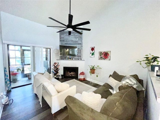 living room featuring a high ceiling, ceiling fan, dark hardwood / wood-style floors, and a fireplace